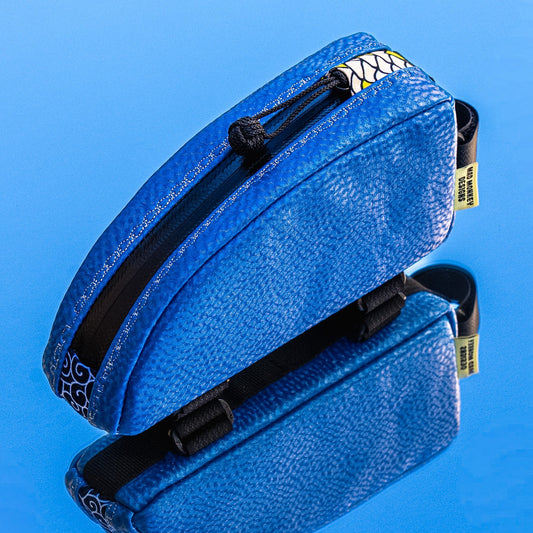 Blue textured Bag with black zippers on a blue background